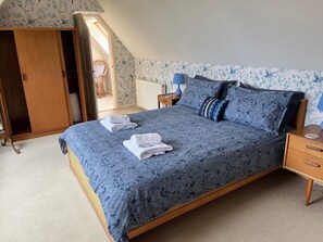 Un dormitorio con cama, mesita de noche, cómoda y ventana con vistas.