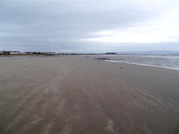 A wide sandy beach with gentle waves, a clear sky, and distant buildings. - Links Quay 42 - a house that sleeps 4 guests in 2 bedrooms (Prestwick)