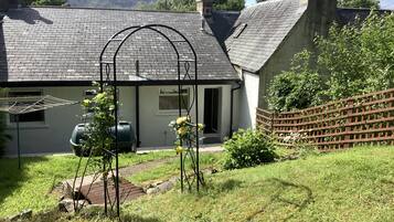 Stroll through the serene garden, surrounded by lush plants and a beautifully manicured lawn.