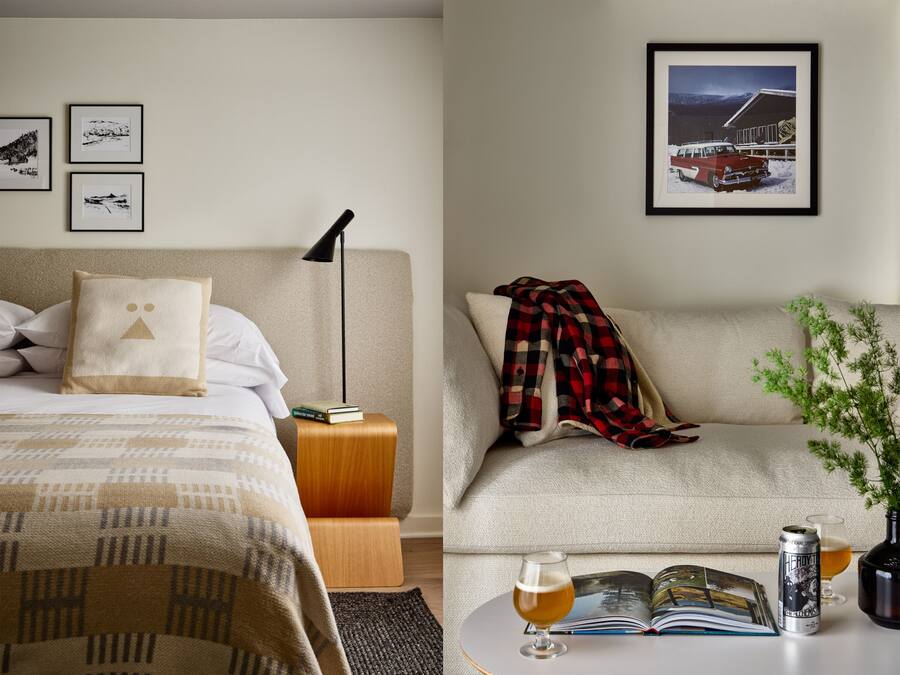 Une chambre d’hôtel avec un lit, un canapé, une table basse avec un livre, un verre de bière et une canette de bière.