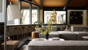 Un salon moderne comprenant un canapé, une table basse, une bibliothèque et une fenêtre donnant sur l’extérieur.