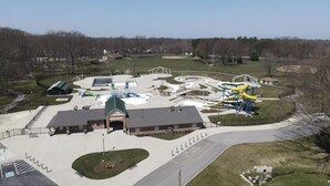 An aerial view of a park with a playground, a building with a green roof, and a parking area. - Gorgeous Ranch Home in Beautiful Westlake Ohio- No Cleaning Fee! (Westlake)