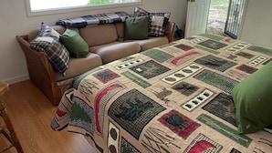 Una habitación acogedora con una cama grande, un sofá y una ventana con vista a zonas verdes.