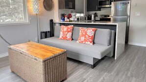 A modern kitchen with dark cabinets, a stainless steel refrigerator, and a built-in microwave.