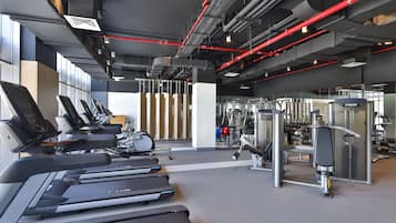 A gym with treadmills, weight machines, and exercise balls.