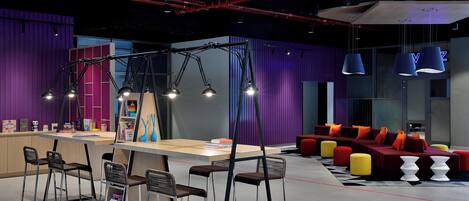 A modern lounge area with a bar, seating, and pendant lighting.