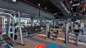 A gym with various exercise equipment, including dumbbells, benches, and weight machines. - Aloft by Marriott Dubai Airport (Dubai)