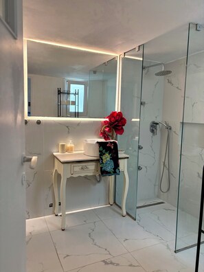 Douche, baignoire à remous, séchoir à cheveux, serviettes fournies