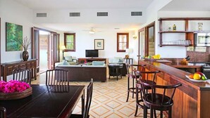 Un amplio espacio de sala con mesa de comedor, bar y cocina.