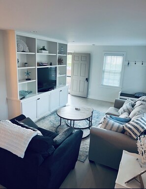 Relax in this stylish living room with a sofa, coffee table, and armchair, perfect for unwinding in front of the flat-screen TV.