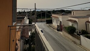 Un balcon donnant sur une rue résidentielle et un pont.
