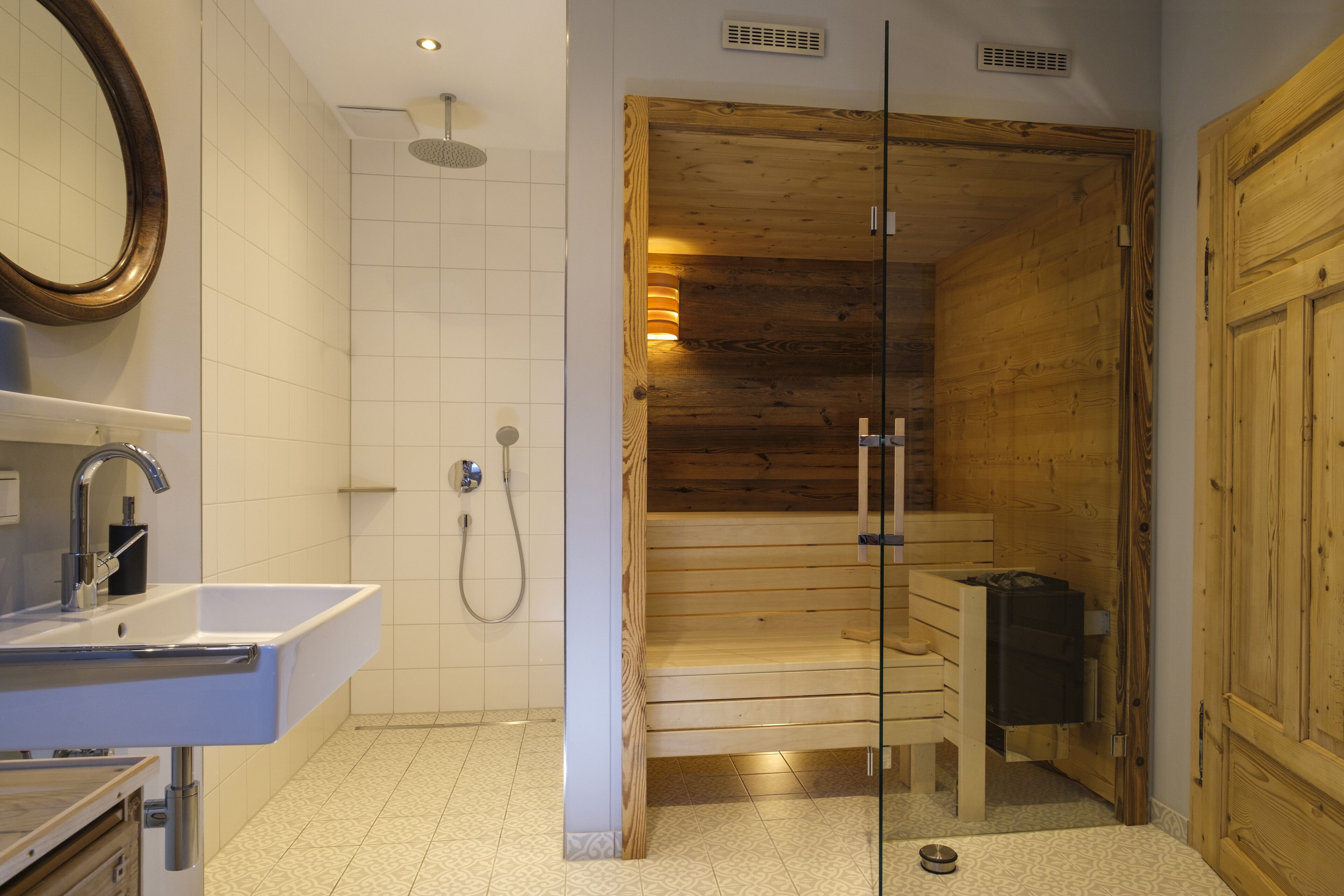 Un baño con sauna de madera, un lavabo y una ducha.