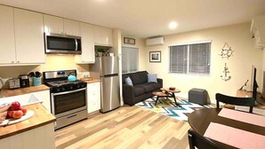 A compact living space with a kitchenette, a dining area, and a seating area. - SoCal Daze, a Cozy Bungalow + Parking, Patio, BBQ (Pasadena)