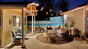 A patio area with outdoor seating, a mural, and string lights. - SoCal Daze, a Cozy Bungalow + Parking, Patio, BBQ (Pasadena)