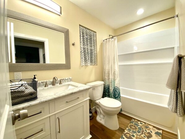 A bathroom with a white sink, a toilet, and a shower curtain.