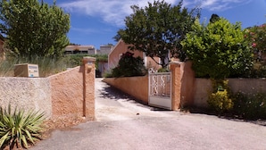 A gated entrance with a concrete path leading to a building.
