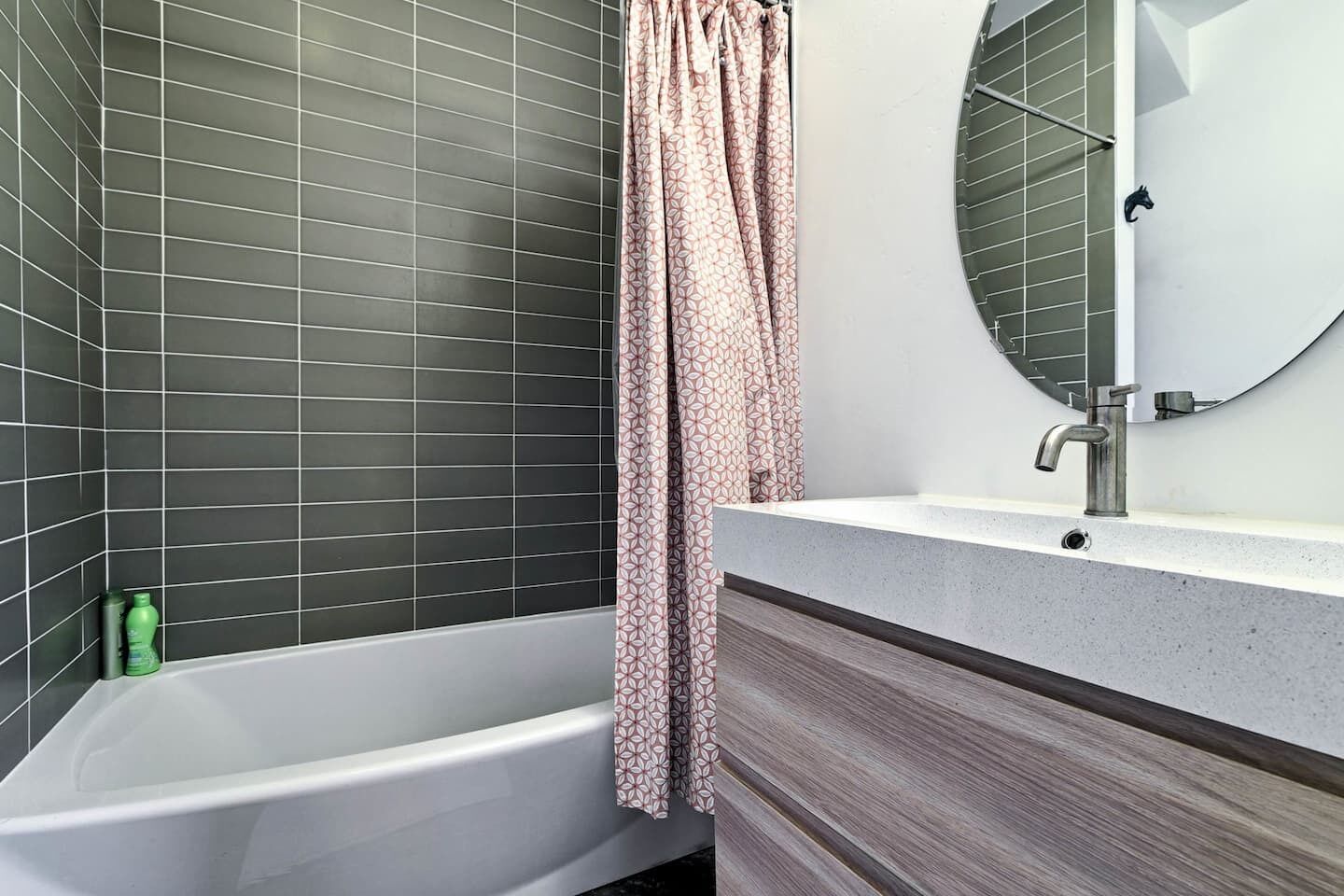 Ein Badezimmer mit Badewanne, Waschbecken mit Spiegel und Duschvorhang.