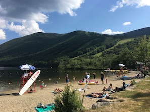 Enjoy a serene lakeside beach experience with a well-maintained sandy beach, umbrellas, and water toys.