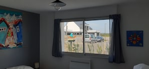 Enjoy a peaceful retreat with a city view from the large window, featuring a comfortable bed and stylish decor.