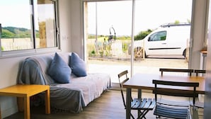 A modern interior with a sofa, wooden table, and chairs. - Ocean, beaches, kitesurfing, surfing 400 m away, ground-floor apartment with very large terrace  (Guidel)