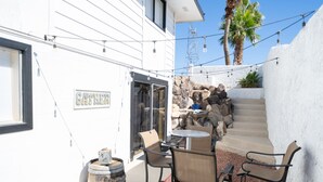 A patio area with a table and chairs, a stone wall, and a sign that reads "GATHER".