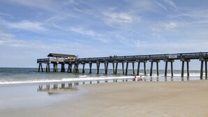 A pier extending into the ocean with a small building at the end. - Family friendly condo, Ocean views (Tybee Island)