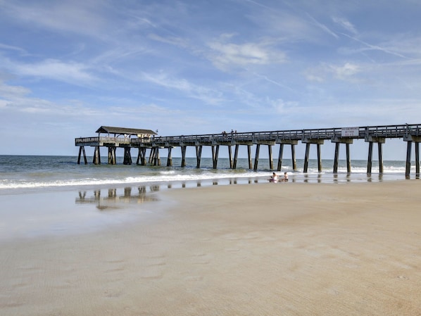 A pier extending into the ocean with a small building at the end.