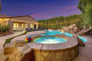 A swimming pool with a hot tub, lounge chairs, and a house in the background. - Echelon: Pool, Spa, Pool Table, Ping Pong table! (Indio)
