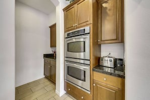 A kitchen with wooden cabinets, stainless steel appliances, and a granite countertop.