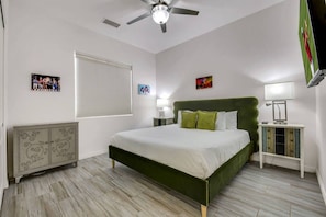 A bedroom with a bed, a ceiling fan, a nightstand, a lamp, and a cabinet.