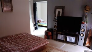 Une chambre avec un lit, une télévision et une petite table.
