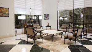 A spacious lobby with a checkered floor, large windows with blinds, and a central coffee table surrounded by chairs. - The World Hotels (São Paulo)