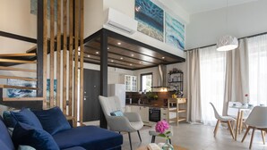 Een moderne woonkamer met een bank, een salontafel met een vaas en een boek, een keukenruimte met een eettafel en een trap met houten leuningen.