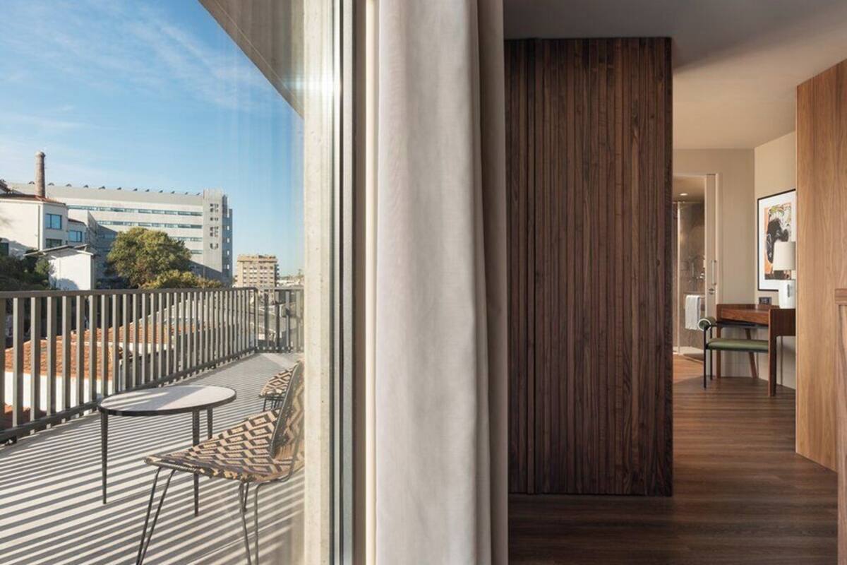 A modern interior with a balcony, a wooden panel wall, and a dining area.