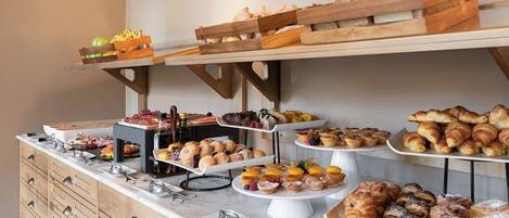 A buffet setup with various food items on multiple serving platters and trays.