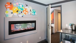 A hallway with a wall-mounted bulletin board and a fireplace. - Samesun San Francisco - Hostel (San Francisco)