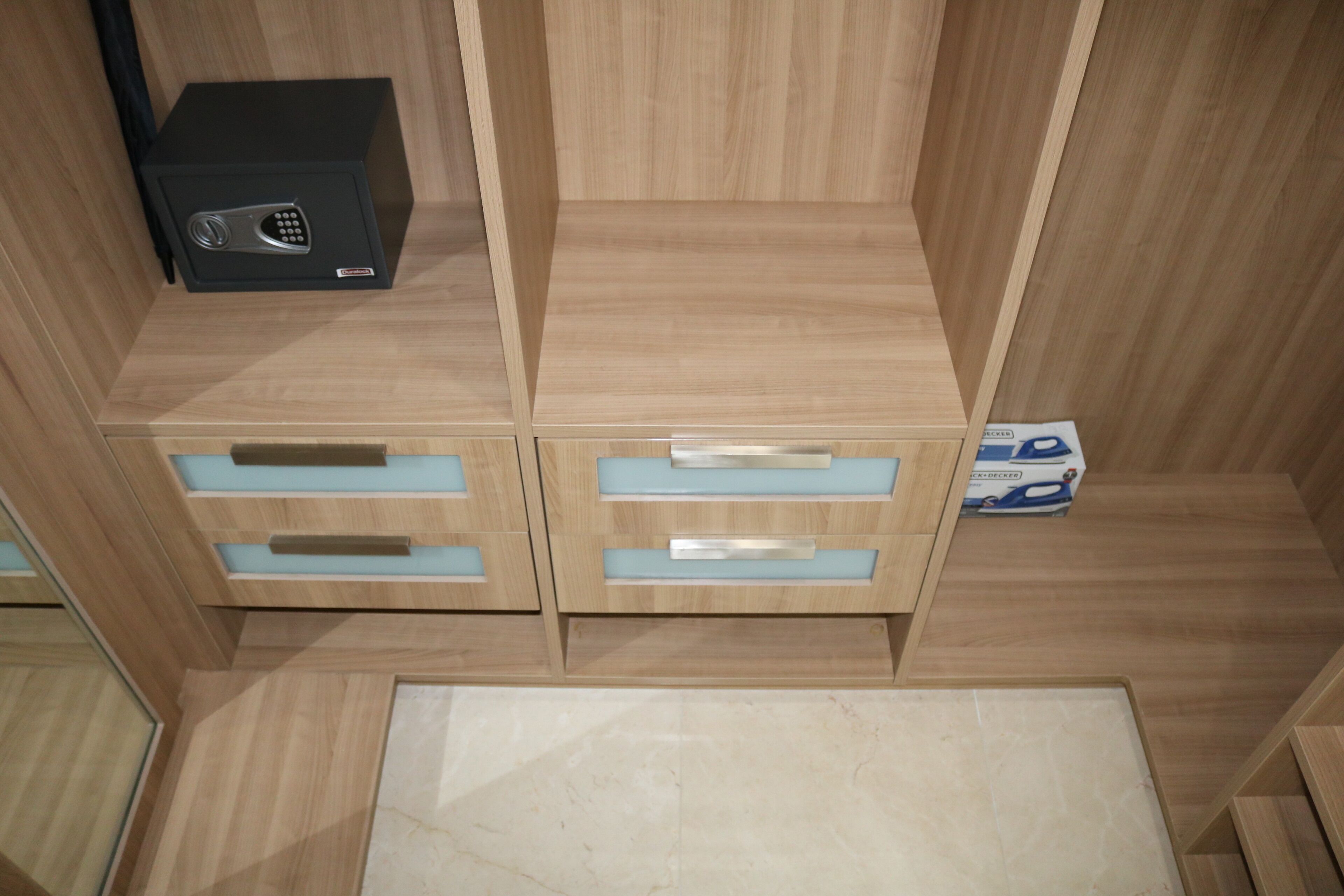 A wooden cabinet with drawers and a black electronic device on top.