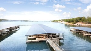 Een pand aan het water met meerdere steigers en een overdekt terras.