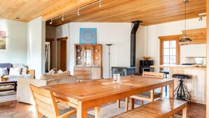 Amplia sala de estar con una mesa de comedor de madera, un sofá y una chimenea.