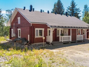 A red wooden house with a covered porch, a chimney, and a gravel driveway. - Tinttityy by Interhome (Nilsiä)