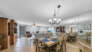 A spacious living area with a dining table, chairs, and a ceiling fan. - Remodeled Beachfront beauty! Inlet Reef 416 (Destin)