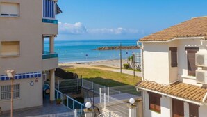 A coastal building with balconies overlooking the sea, a clear sky, and a sandy beach in the background. - Blue Sea by Interhome (Cunit)