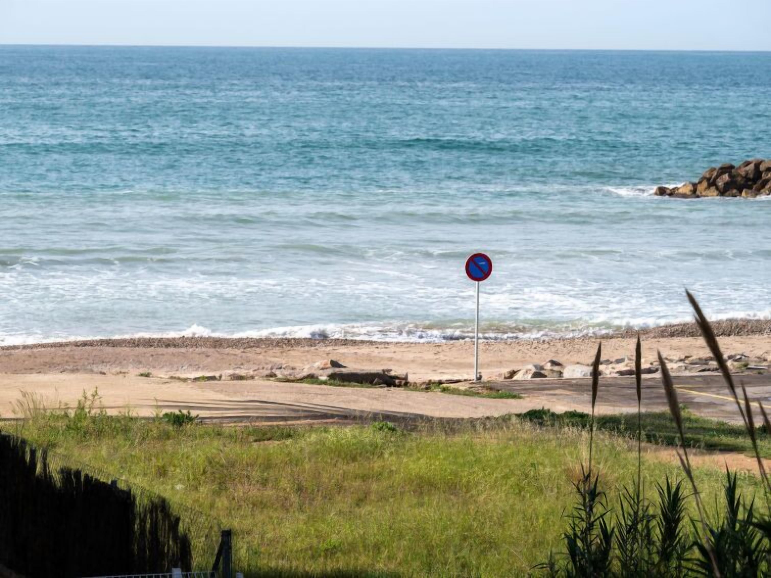 Une plage où la baignade est interdite, avec un rivage rocheux et des vagues.