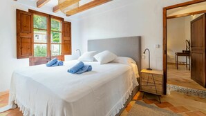 A bedroom with a large bed, wooden beams, a window with open shutters, and a nightstand with a lamp. - Wonderful private villa for 6 people with WIFI, A/C, TV and patio (Andratx)