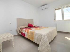 Relax in this serene bedroom with a single bed, bedside table, and large window.