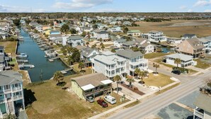 A coastal residential area with houses, a marina, and a road. - 5 bedrooms, 4 bathrooms,  2nd Row Home w/ Heated Pool! (Supply)