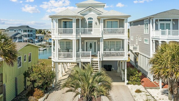 A multi-story building with balconies, a covered entryway, and a view of the water. - 5 bedrooms, 4 bathrooms,  2nd Row Home w/ Heated Pool! (Supply)