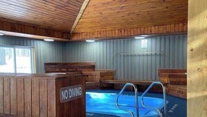 Een binnenzwembad met houten wanden en een bordje met de tekst 'No Diving'.
