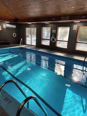 Swim laps in the pool surrounded by windows and a metal ladder.