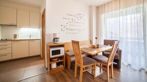 Una cocina moderna con armarios blancos, un microondas y una cafetera sobre la encimera.